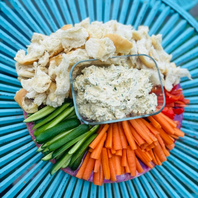 Dip with crackers and vegetables on a blue plate