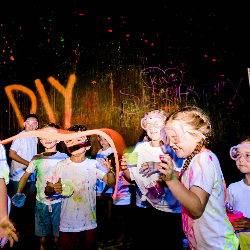Kids having fun throwing paint at each other in our Splatter & Splash Room